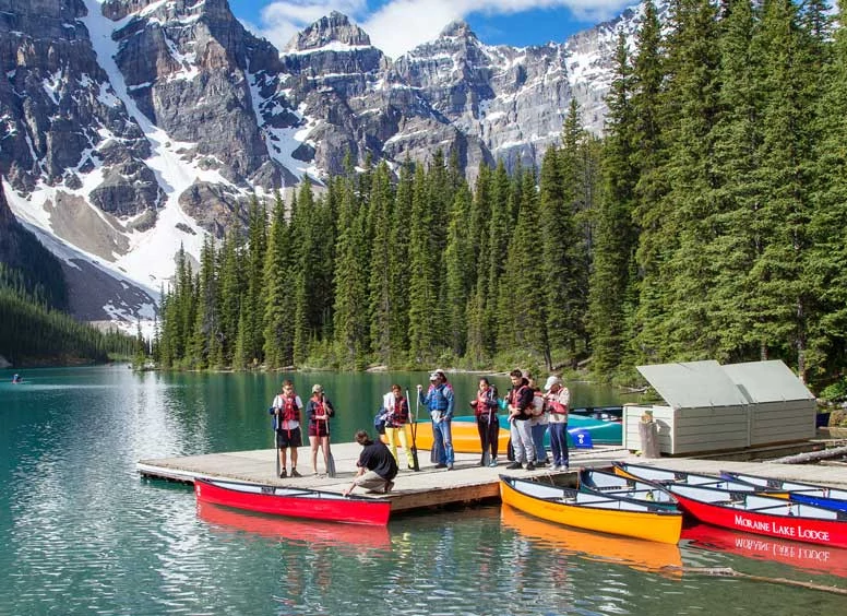 People standing around the canoe rental at Moraine Lake.