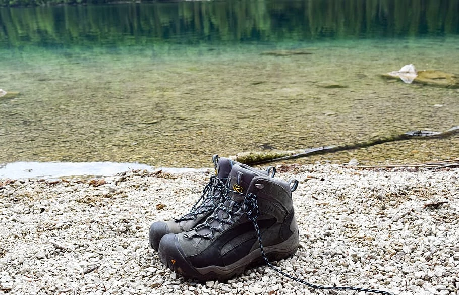 Pair of boots along a path and river.